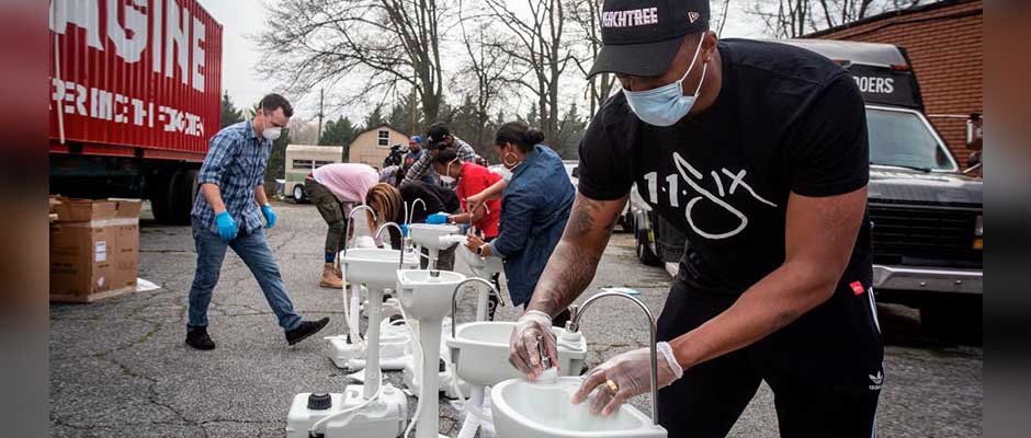 El artista de hip hop Lecrae monta una estación de lavado portátil en College Park, Georgia. (Foto AP/ Ron Harris),